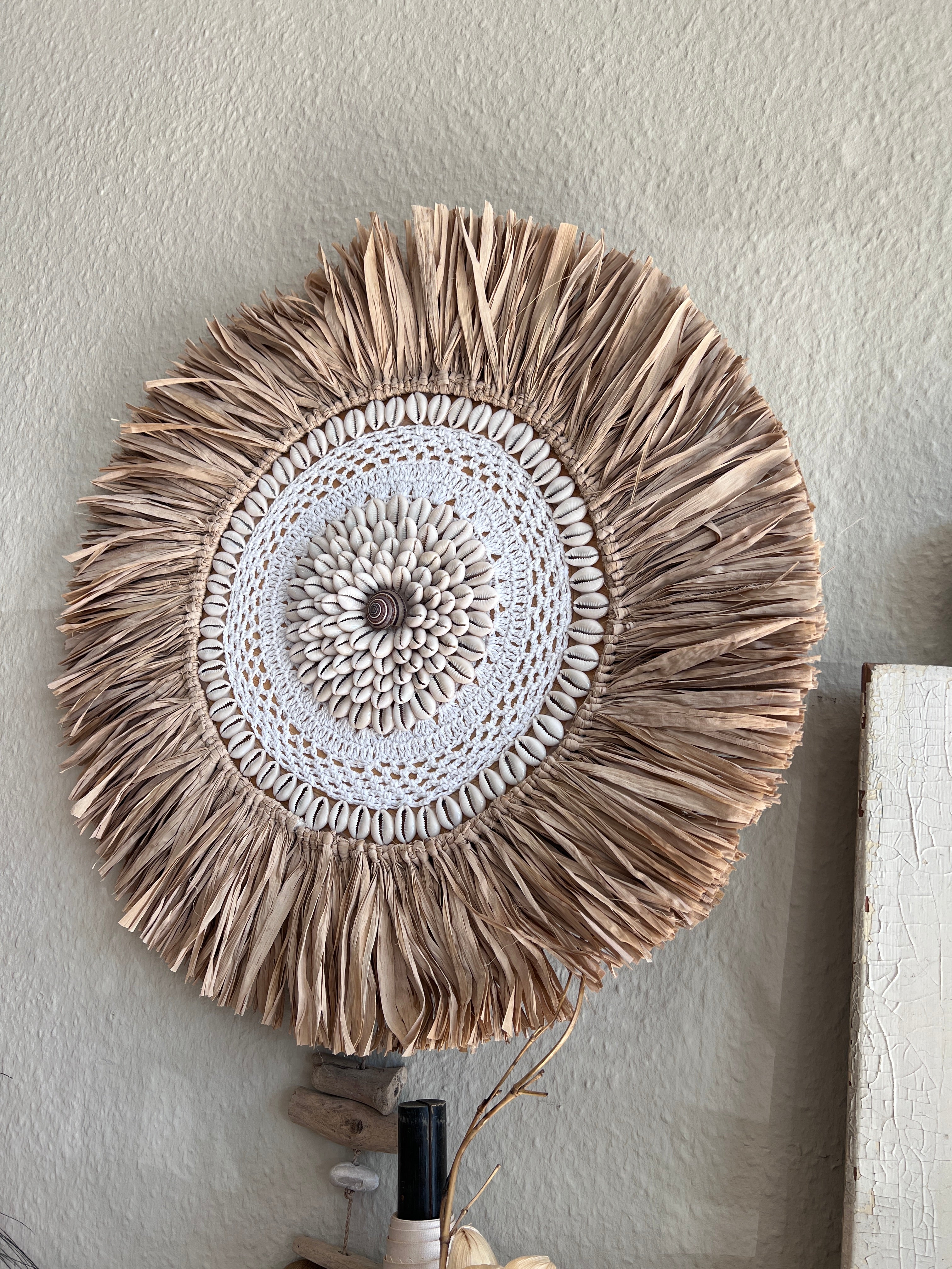 Wanddekoration aus Stroh mit Muschel